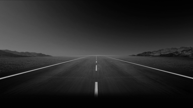 A black and white photo of an empty road.